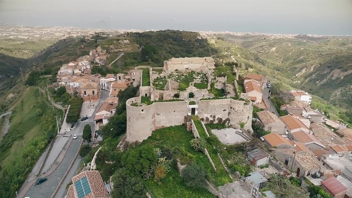 Paesaggio montano al tramonto con cime innevate e cielo arancione